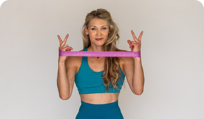 Alya Titarenko stretching a pink resistance band behind her shoulders